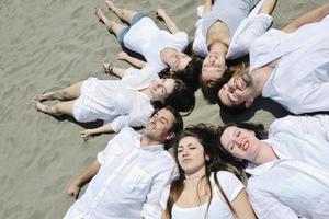 gruppo di contento giovane persone nel avere divertimento a spiaggia foto