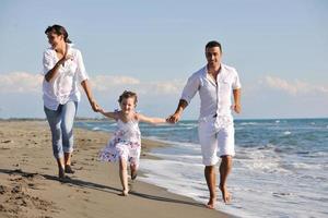 contento giovane famiglia avere divertimento su spiaggia foto