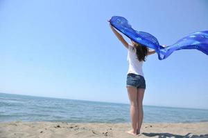 bellissimo giovane donna su spiaggia con sciarpa foto