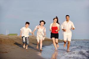 contento giovane famiglia avere divertimento su spiaggia foto