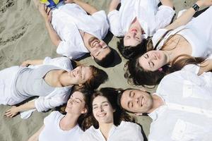 gruppo di contento giovane persone nel avere divertimento a spiaggia foto