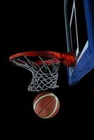 palla da basket e rete su sfondo nero foto