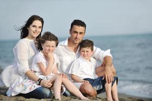 contento giovane famiglia avere divertimento su spiaggia foto