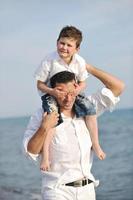 contento padre e figlio avere divertimento e godere tempo su spiaggia foto