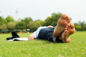 giovane donna che legge un libro nel parco foto