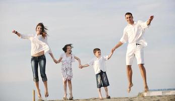 contento giovane famiglia avere divertimento su spiaggia foto