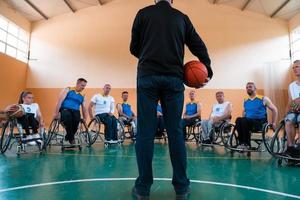 selettore io spiegare nuovo tattica per pallacanestro Giocatori nel sedie a rotelle, Giocatori sedersi nel sedie a rotelle ascoltando per il selettore foto