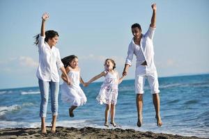 contento giovane famiglia avere divertimento su spiaggia foto