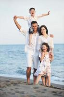 contento giovane famiglia avere divertimento su spiaggia foto