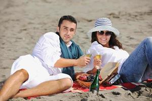 giovane coppia godendo picnic su il spiaggia foto