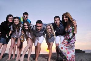 gruppo di giovane persone godere estate festa a il spiaggia foto