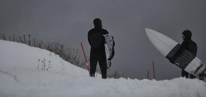 artico surfers in esecuzione su spiaggia dopo fare surf foto