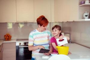 poco ragazza e mamma fabbricazione gusto torta nel kithen famiglia avendo divertimento a casa foto