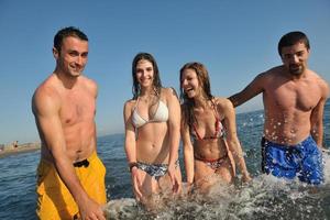 contento persone gruppo avere divertimento e in esecuzione su spiaggia foto