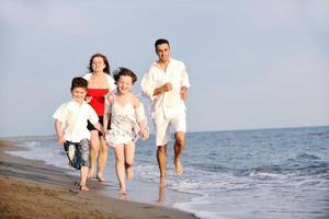 contento giovane famiglia avere divertimento su spiaggia foto