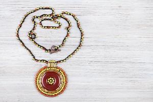 collana con pelle pendente su grigio tavola foto