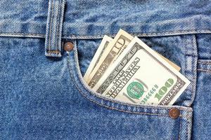 noi dollaro banconote nel il giusto davanti tasca di blu jeans. concetto di Salvataggio i soldi o tasca spese foto