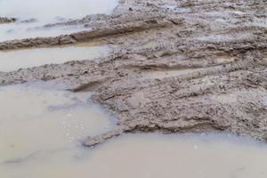 sporco argilla fango strada con pneumatico brani a giorno tempo - pieno telaio sfondo con difficile sole leggero foto
