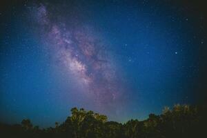 il latteo modo nel il blu notte cielo sopra il foresta a blu roccia proprietà. foto