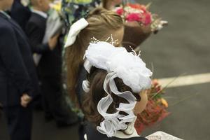 alunni di prima elementare con fiori. primo giorno di scuola. scuola vacanza. fiori per insegnante. foto