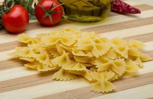 crudo farfalle su di legno tavola e di legno sfondo foto