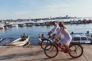 anziano coppia godendo un' bellissimo mattina insieme equitazione un' bicicletta di il mare. selettivo messa a fuoco foto