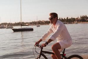 anziano coppia godendo un' bellissimo mattina insieme equitazione un' bicicletta di il mare. selettivo messa a fuoco foto