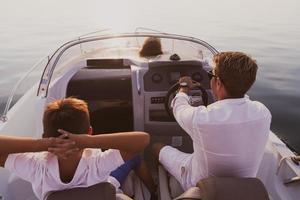 un' anziano coppia nel casuale abiti con loro figlio godere mentre equitazione un' barca a mare a tramonto. il concetto di un' contento famiglia. selettivo messa a fuoco foto