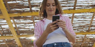 smartphone donna sms su cellula Telefono a spiaggia foto