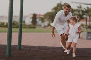 un anziano uomo nel casuale Abiti con il suo figlia spende tempo insieme nel il parco su vacanza. famiglia volta. selettivo messa a fuoco foto