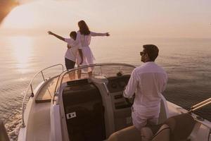 un' anziano coppia nel casuale abiti con loro figlio godere mentre equitazione un' barca a mare a tramonto. il concetto di un' contento famiglia. selettivo messa a fuoco foto