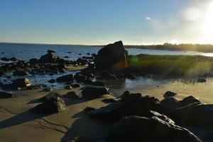 grande rocce su il spiaggia riva durante Basso marea foto