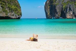 turista in costume da bagno giallo e cappello, viaggiatore felice che prende il sole alla spiaggia della baia di maya sull'isola di phi phi, krabi, thailandia. punto di riferimento, destinazione di viaggio nel sud-est asiatico, vacanza e concetto di vacanza foto