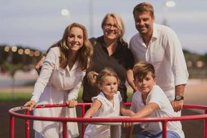 un anziano coppia nel casuale Abiti con loro bambini e nonna trascorrere tempo insieme nel il parco su vacanza. famiglia volta. selettivo messa a fuoco foto