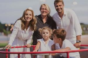 un anziano coppia nel casuale Abiti con loro bambini e nonna trascorrere tempo insieme nel il parco su vacanza. famiglia volta. selettivo messa a fuoco foto