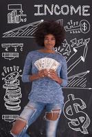 nero donna Tenere i soldi su grigio sfondo foto