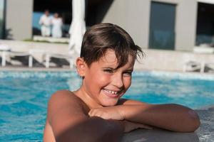 il ragazzo gode un' estate giorno nuoto nel il piscina. il concetto di un' famiglia vacanza. selettivo messa a fuoco foto