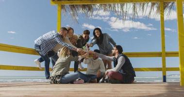 gruppo di amici avendo divertimento su autunno giorno a spiaggia foto