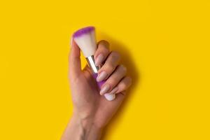 femmina mani con un' bellissimo manicure su un' giallo sfondo, in alto Visualizza foto