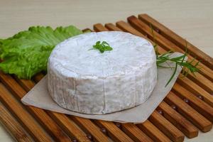 Camembert formaggio su di legno tavola e di legno sfondo foto