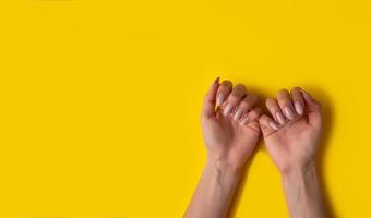 femmina mani con un' bellissimo manicure su un' giallo sfondo, in alto Visualizza foto
