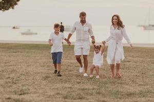 anziano coppia nel casuale Abiti con loro figli, ragazzo e ragazza godere il spiaggia la spesa un' vacanza insieme. famiglia tempo . selettivo messa a fuoco foto