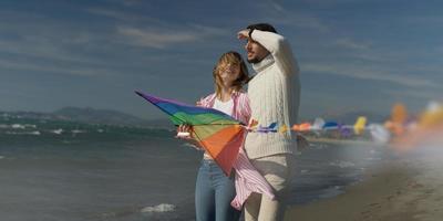 contento coppia avendo divertimento con aquilone su spiaggia foto