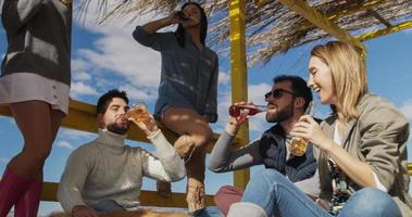 gruppo di amici avendo divertimento su autunno giorno a spiaggia foto