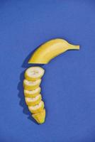 banane e fette isolato su un' blu sfondo foto
