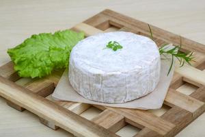 Camembert formaggio su di legno tavola e di legno sfondo foto