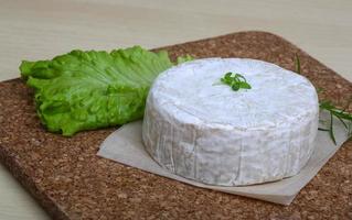 Camembert formaggio su di legno tavola e di legno sfondo foto