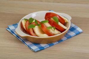 caprese nel un' ciotola su di legno sfondo foto