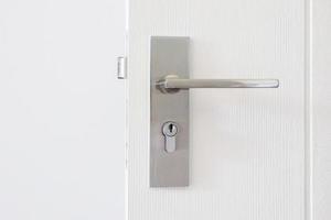 moderno porta maniglia con buco della serratura su bianca porta foto