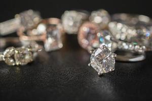 anelli di diamanti gioielli incastonati su sfondo nero da vicino foto